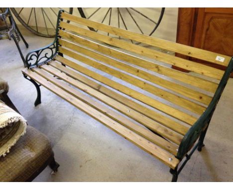 A wrought iron end garden bench with pressure treated wooden slats  