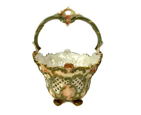 ROYAL WORCESTER BASKET, the lattice pierced circular bowl moulded with scrolls and shells, with swing handle, on four scroll 