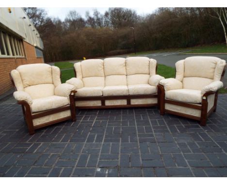 A pine framed three piece suite comprising three seater sofa and two armchairs, recently re-upholstered in cream