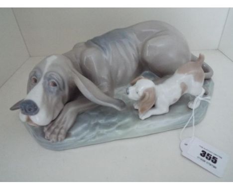 Nao by Lladro - a large figurine depicting a bloodhound, lying down with puppy at his side, the whole mounted on a base, 8 cm