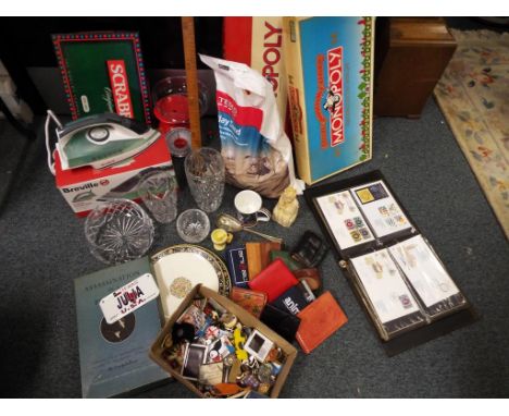 A large mixed lot to include Monopoly Games, a file of first edition cover stamps, a large selection of lady's purses and wal