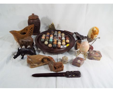 A good mixed lot to include a wooden solitaire base containing hardstone pieces, carved animals, sandstone trinket dishes, on