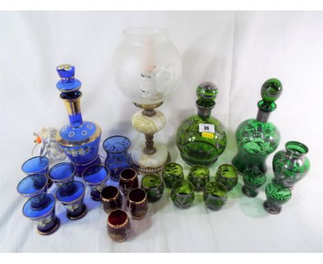 A good quality onyx and brass table lamp with a glass shade and a quantity of good quality decanters with matching drinking g