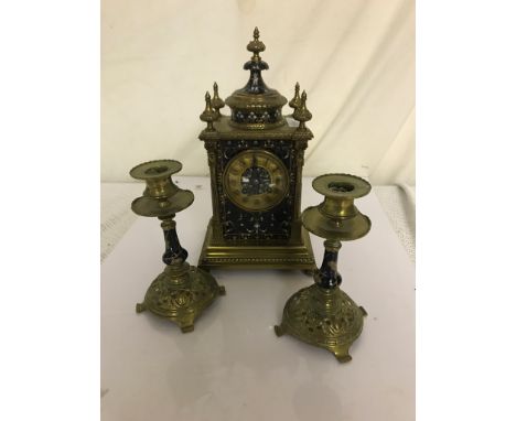 A 19th century champleve enamelled clock garniture with eight-day movement striking on a gong