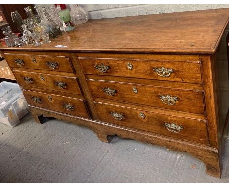 An 18th century oak sideboard, set with six long drawers, later brass swing handles and raised on bracket feet, 86cm high, 17