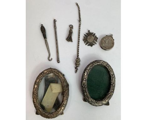 A pair of small oval silver photograph frames; with a silver swizzle stick; a circular locket; two silver watch fobs; a small