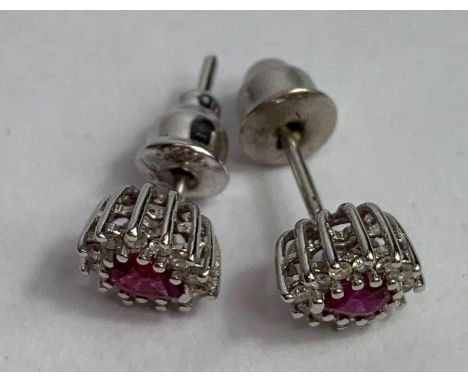 A pair of ruby and diamond cluster ear studs, in unmarked white metal, the tear shaped ruby enclosed by twelve small brillian