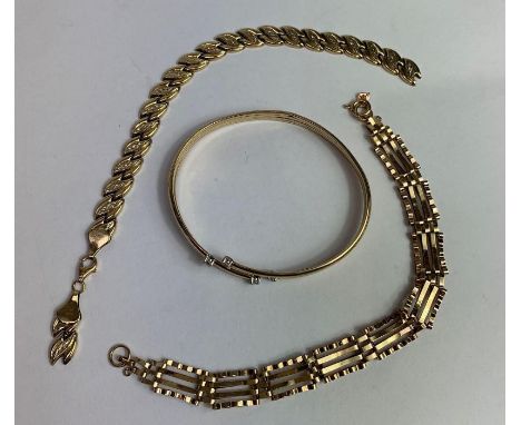 A 9 carat gold four bar gate link bracelet; a 9 carat gold bracelet of hollow links; and a torc bangle with stone terminals t