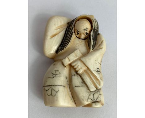 A 19th/20th century Japanese ivory netsuke in the form of a man holding a hammer, with a rotating face, artist signed to the 