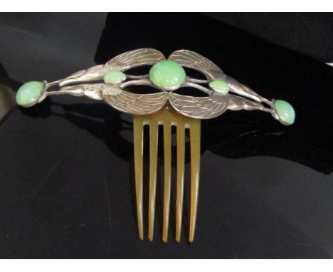 An Art Nouveau hair comb with four open winged birds holding scarab beetles and pale green cabochons, possibly jade, 19cm wid