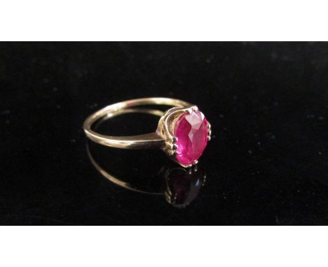 A gold ruby ring, shank split, unmarked. Size P, 2g