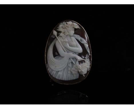 A large carved shell Cameo depicting a Bacchant with flowing scarf holding a basket of flowers, 6.5cm x 5cm in a 9ct gold fra
