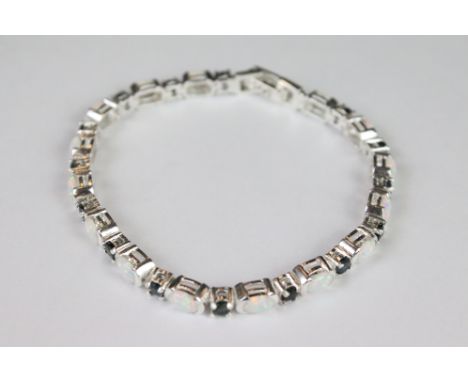 A silver opal and sapphire line bracelet. 