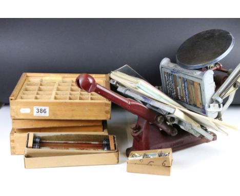 A vintage hand printing press together with a large quantity of printing blocks and letters within wooden storage boxes. 