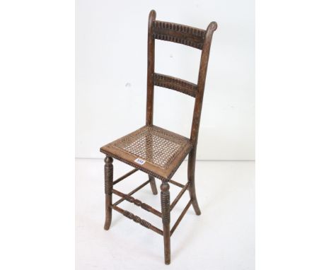 19th century Child's Correction Chair with cane seat and raised on turned bobbin supports, 37cm wide x 95cm high 