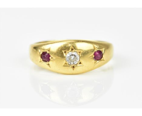 An 18ct yellow gold, ruby and white stone gypsy style ring, with central round cut stone flanked with a ruby either side, in 