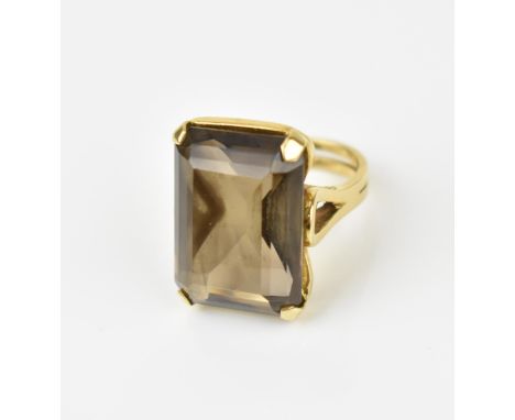 An 18ct yellow gold and smoky quartz dress ring, with large step cut stone in four corner claw mount, the shank stamped 750, 