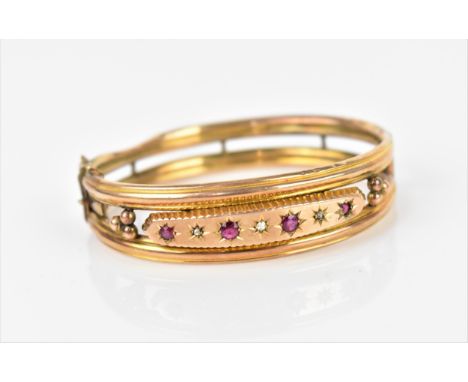 A Gypsy style yellow metal, ruby and diamond bangle bracelet, with starburst set old cut diamonds and rubies with open box cl