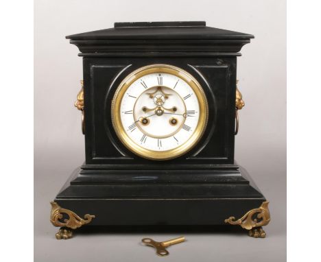 A Victorian slate mantel clock. With enamel dial having visible anchor escapement. With gilt metal lion mask handles and brac