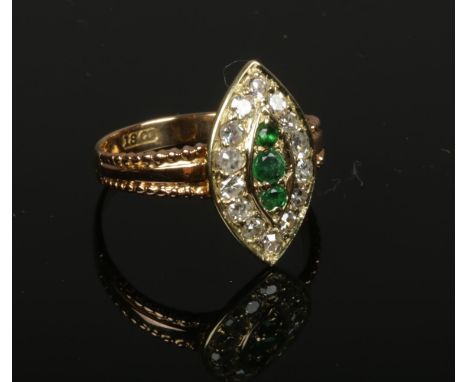 An 18ct gold emerald and diamond cluster ring set on a navette shaped panel. 3 grams gross weight, size M.  