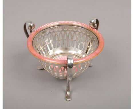 An early 20th century white metal openwork basket. With three double scrolling handles terminating on paw feet and ornamented