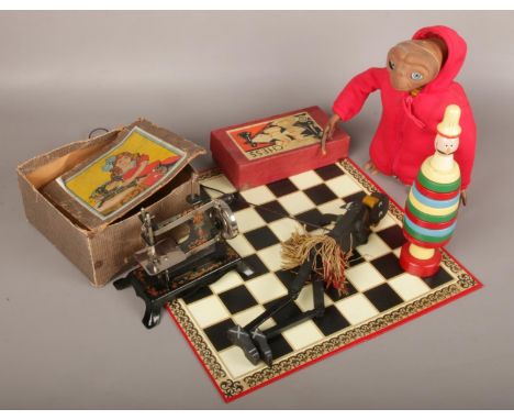A collection of mostly vintage toys to include child's sewing machine, wooden African puppet, wooden stacking clown, chess bo