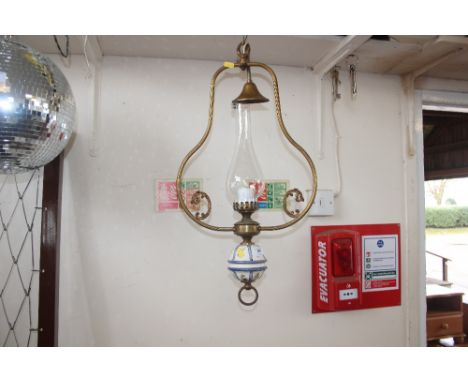 A pottery and brass oil lamp with glass chimney 