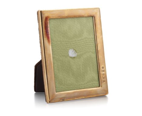 A 9ct gold mounted photo frame, the plane gold frame with plush brown fabric easel back and fittings and glass front, London 