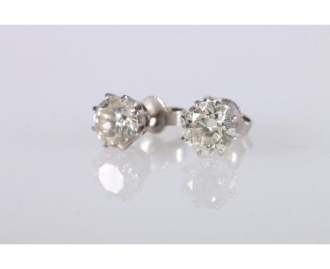 Pair of white metal and diamond ear studs, each set with 1ct diamonds, 14kt white gold butterflies, 2.1g gross.   Slightly ye