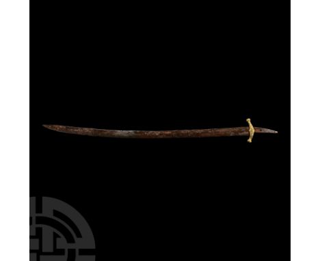 9th century A.D.. A single-edged hand-forged sabre with a gently curving blade, an iron band welded beneath the cross guard, 