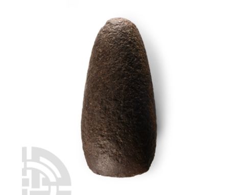 Neolithic Period, circa 7500-5300 B.C. A large pecked and ground axehead with a curved cutting edge and a narrow rounded butt