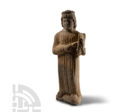 Circa 5th-4th century B.C. Carved in the round, a figure wearing a floor-length robe and holding a stringed instrument in the