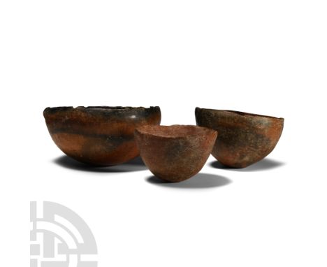 Early Bronze Age, circa 2700-1900 B.C. Group of three hemispherical bowls, each with a thick rounded rim, one with lateral sp