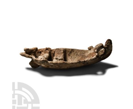 Circa 600-480 B.C. Modelled in the round as a miniature flat-bottomed boat with sternpost and three thwarts, one supporting t