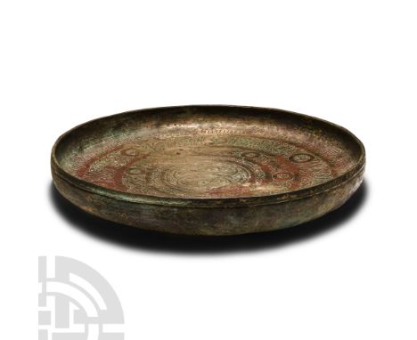 12th century A.D.. Squat dish or shallow bowl with raised rim; central looped interlace motif on a hatched foliage field, con