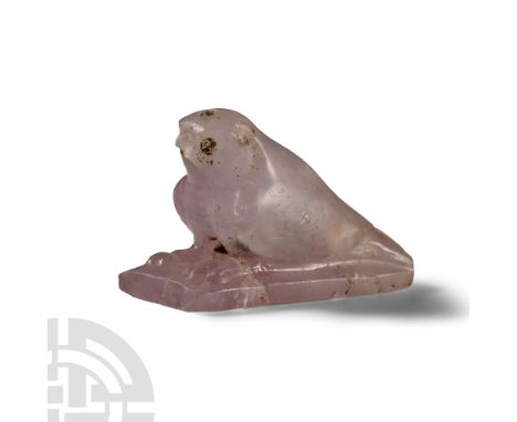Late Period, 664-332 B.C. Carved in the round, the falcon seated on a rectangular base with outstretched talons, the wings ne