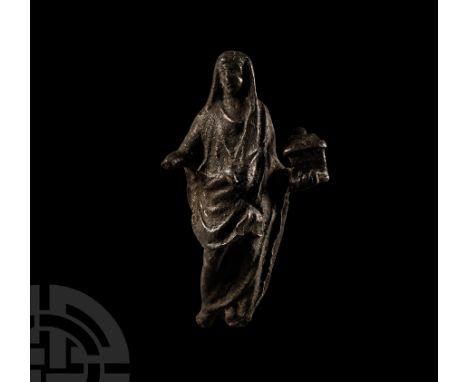 1st century B.C.-1st century A.D.. Advancing wearing an ankle-length toga drawn over the head as a cowl, the left hand suppor