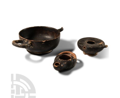 4th-2nd century B.C. Group of three comprising: oil lamp with integral strap to rear; kylix with impressed palmettes design; 