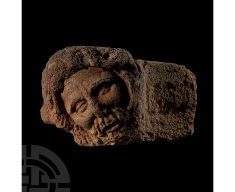Circa 2nd century A.D.. Statue or frieze fragment with male head modelled in the half-round; circular face with large almond-