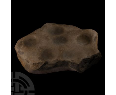 Circa 2nd millennium B.C. Irregular slab fragment with weathered upper face, cluster of seven cup-marks without surrounding r