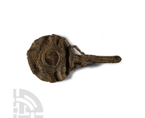 2nd-3rd century A.D.. With ribbed handle, discoid plate with raised rib to one face, running scrolls to the other, lateral st