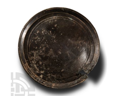 1st-3rd century A.D.. With one flat surface, reverse with thick flared rim, incised concentric rings, carinated profile. Cf. 