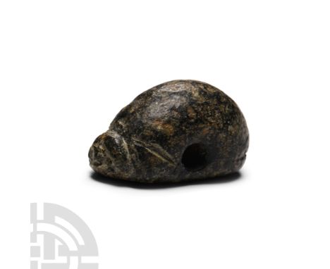 3rd-2nd millennium B.C. Plano-convex in profile, oval in plan with facial detailing to the knop finial, underside with incuse