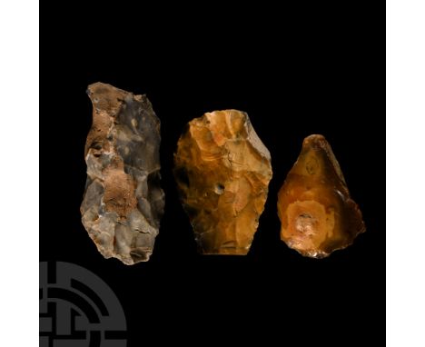 Palaeolithic to Neolithic Period, circa 200,000-6000 B.C. Group of three irregular grey and honey-coloured flint cleavers wit