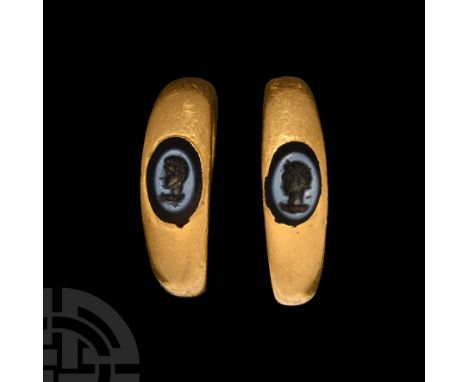 2nd century A.D.. Comprising two matching solid hoops with expanding shoulders, each set with a dark blue nicolo intaglio, on