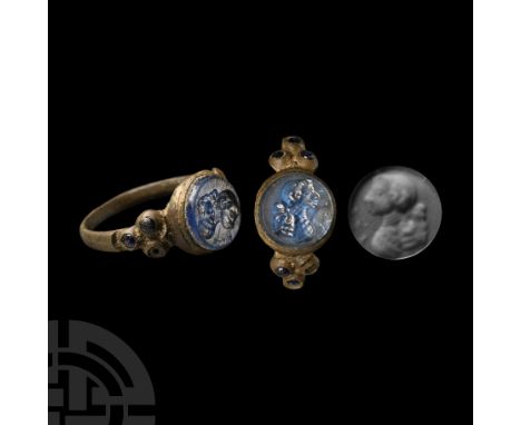 18th century A.D.. Slender hoop with three roundels to each shoulder, each set with a blue glass cabochon; tiered round bezel