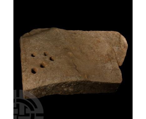 Circa 2nd millennium B.C. Rectangular worked stone block with one irregular edge; the thicker, dressed edge with a group of f