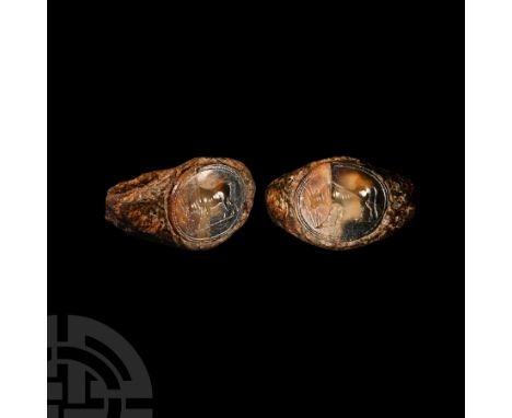 1st-2nd century A.D.. Slender hoop expanding to a broad bezel, inset sardonyx cloison intaglio depicting a grazing bull on a 