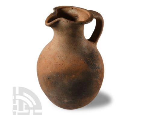 1st-4th century A.D.. With conical lower body and rounded shoulder, broad mouth with pinched pouring lip and thick handle to 