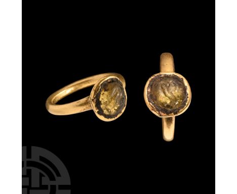 Circa 3rd-4th century A.D.. With tapering shoulders, cup bezel, inset green glass cabochon with intaglio bird and flower moti